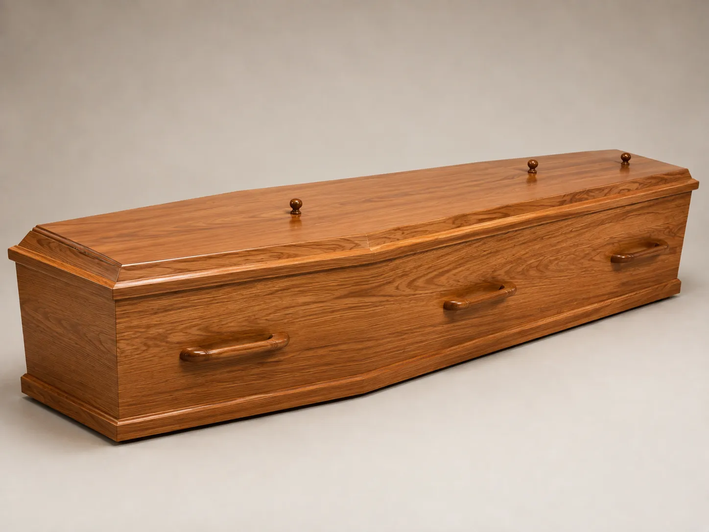 Simple wood-finish coffin with plain wooden handles