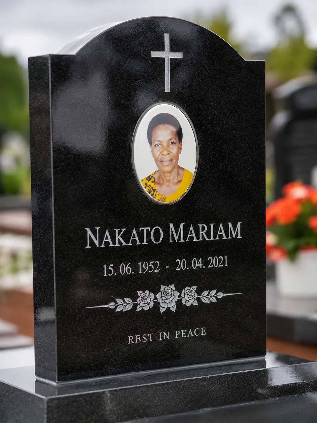 Black granite headstone with portrait plaque and cross